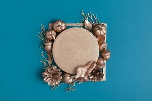 Still life of golden acorns, cones, leaves and pumpkins on a turquoise background with a pedestal photo