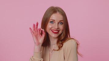Positive businesswoman girl showing ok gesture, like sign positive something good on pink background video