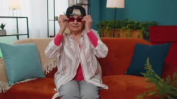 Stylish granny in marijuana cap hat, wearing red sunglasses, looking at camera with charming smile video