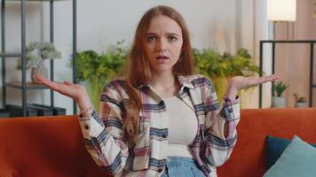 Confused woman raising hands in indignant expression, asking why, what reason of failure at home video
