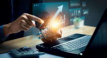 Businessman interacting with futuristic financial dashboard, analyzing rising virtual charts and data trends on transparent interface. Concept of smart analytics, AI powered finance, business growth. photo