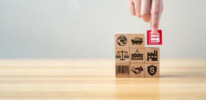 Tariff and international trade concept with wooden blocks showing import, export, shipping, factory, agreement, and tax symbols. Global commerce, customs duty, and economic regulation strategy. photo