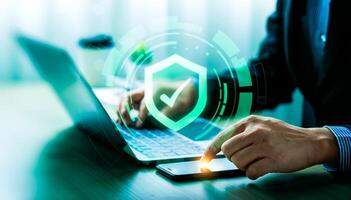 Business cyber defense and information security concept with digital shield icon. Businessman protecting data with multi-device access control, cybersecurity technology, secure authentication system photo