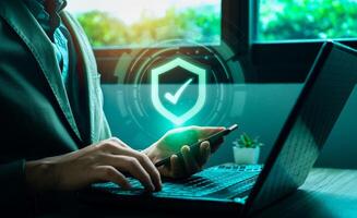 Business cyber defense and information security concept with digital shield icon. Businessman protecting data with multi-device access control, cybersecurity technology, secure authentication system. photo