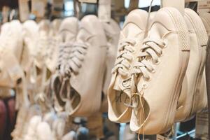 Classic Canvas Sneakers on Display in a Fashion Retail Store. Several pairs of canvas sneakers hanging neatly on display in a modern fashion retail store. Ideal for themes related to fashion. photo