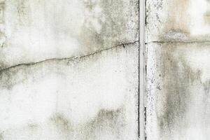 Old Cracked Concrete Wall with Stains and Weathered Texture. an aged concrete wall with visible cracks, mold stains, and discoloration from weathering. decay and moisture damage. photo