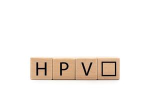 Wooden block with the letters HPV isolated on white background. Copy space and Clipping Path. Medical concept. HPV, female health concept. photo