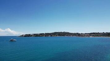 View of the Cote d'Azur featuring the Chateau Grimaldi and Musee Picasso in Antibes, France. The scene includes a clear blue sky and calm turquoise waters. video