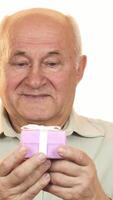 Joyful elderly man radiating happiness while presenting a beautifully wrapped gift box video