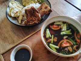 A bowl of soup and rice on a table photo