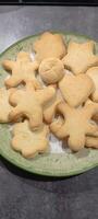 figured homemade cookies of different shapes on a flat plate. Mobile photo. photo
