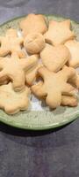 figured homemade cookies of different shapes on a flat plate. Mobile photo.. photo