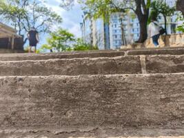 A close up of a concrete staircase with a person walking on it. The image has a mood of loneliness and solitude, as the person is walking alone on the steps photo