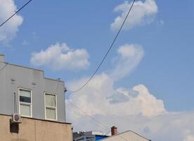 A building with a chimney and a window on the side. The sky is blue and there are clouds photo