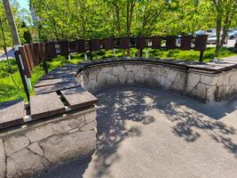 A stone wall with a bench on the side of it. The bench is made of wood and is surrounded by a stone wall photo