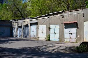 A row of old blue doors sit in front of a building. The building is old and has a rustic appearance. The doors are open and the building is empty photo