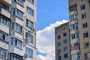 Two buildings with many windows and a cloudy sky in the background. The buildings are tall and have a modern look photo