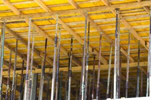 A construction site with many wooden posts and beams. Scene is one of hard work and progress, as the workers are busy building a structure photo