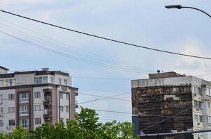 A tall building with a lot of wires above it. The sky is cloudy and the sun is not visible photo