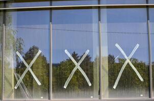 Three windows with white X's on them. The X's are drawn on the glass with a marker photo