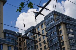 A tall building with a lot of windows and a wire running across the top. The sky is blue and there are clouds in the background photo