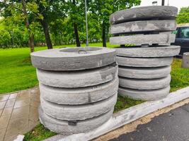 A pile of gray concrete blocks sits on the sidewalk. The blocks are stacked in a way that they are almost touching the curb. The scene is quiet and peaceful, with no people or vehicles in the area photo