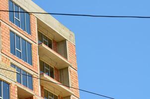 A building with a lot of windows and a wire running across the top. The sky is blue and clear photo