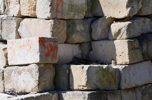 A pile of bricks with red writing on them. The bricks are stacked in a corner photo