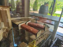 A display of wooden knives with a glass case. The knives are wooden and have a rustic look to them photo