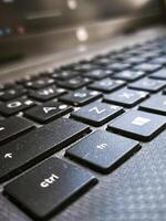 A close up of a keyboard with the letters h, w, and c on it. The keyboard is black and the letters are white photo