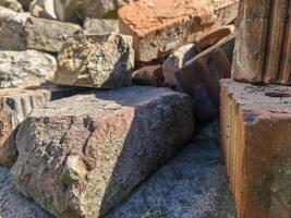A pile of bricks and rocks with a shadow cast on it. Scene is somewhat somber and desolate photo