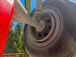 A tire with a metal rim is shown in the image. The tire is black and has a white rim. The tire is on a vehicle, and the image has a mood of a vehicle in motion photo