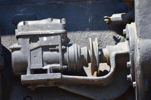 A black engine part with a white circle on it. The engine part is old and rusty photo