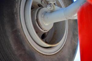 A tire with a red cloth draped over it. The tire is old and worn photo