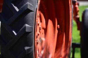 A red and black tractor tire with a black rim. The tire is the main focus of the image, and it is clear that it is a tire on a tractor photo