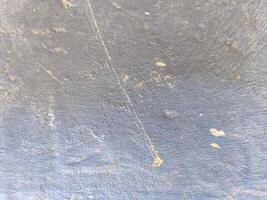 A grey wall with a few scratches and marks. The wall appears to be old and worn, with a sense of history and character photo