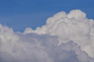 The sky is blue and the clouds are white. The clouds are fluffy and the sky is clear photo