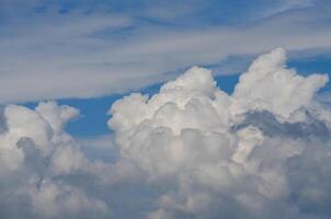 The sky is blue with a few clouds scattered throughout. The clouds are white and fluffy, giving the sky a peaceful and serene appearance photo