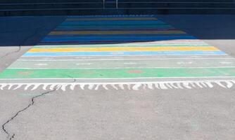 A colorful rug is laid out on the ground. The rug is multi-colored and has a striped pattern photo