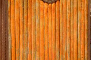 The wooden door has a rustic look to it. The wood is weathered and has a brownish tint. The door is open, revealing a view of the inside photo