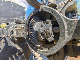 A black and dirty engine part with a white label. The engine part is in the middle of the image photo