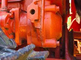 A red engine with a hole in the middle. The engine is old and rusty photo