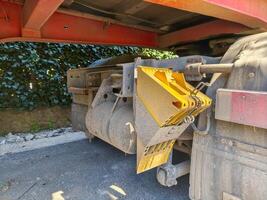 A yellow and red truck with a yellow and red bucket on the back. The bucket is attached to the back of the truck and is used for dumping photo