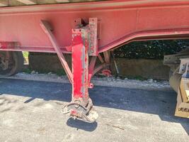 A red truck with a red trailer hitch. The hitch is rusted and has a lot of dirt on it photo