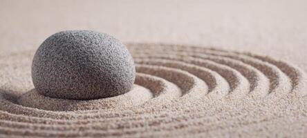 The tranquil stone surrounded by gentle concentric circles of sand photo