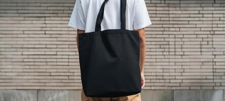 The stylish black tote bag on a casual man in an urban setting. photo