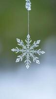 snowflake hanging from a wire on a green background photo