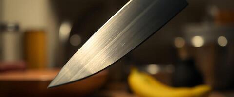 close up of a knife with a banana in the background photo