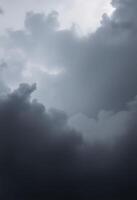 A dark cloudy sky with a few clouds photo