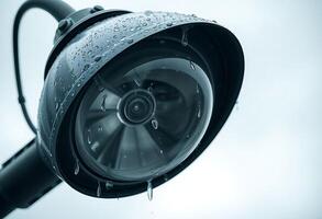 A close up of a surveillance camera with rain drops on it photo